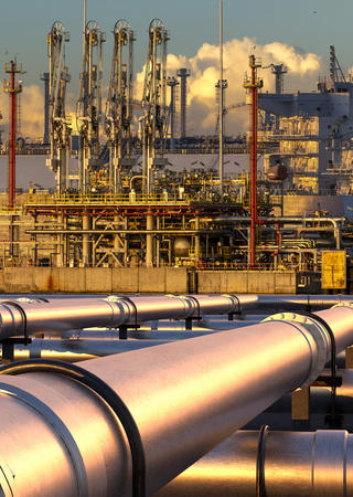 Metal pipeline supplying a boat in the background